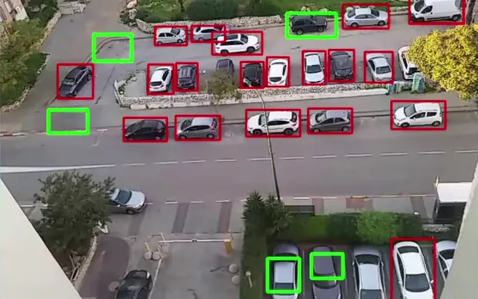 הזנת מצלמת Parking Detector: חניות תפוסות מוקפות באדום ע״י מודל YOLOv5, חניות פנויות מוקפות בירוק